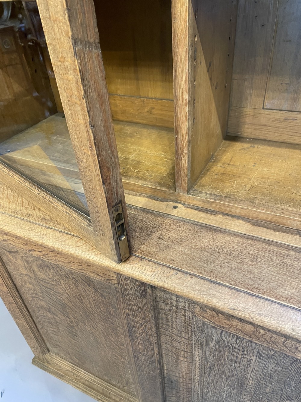 A tall Victorian light oak two-part bookcase with two upper glazed doors revealing adjustable shelves and a two-door cupboard base. View XVI