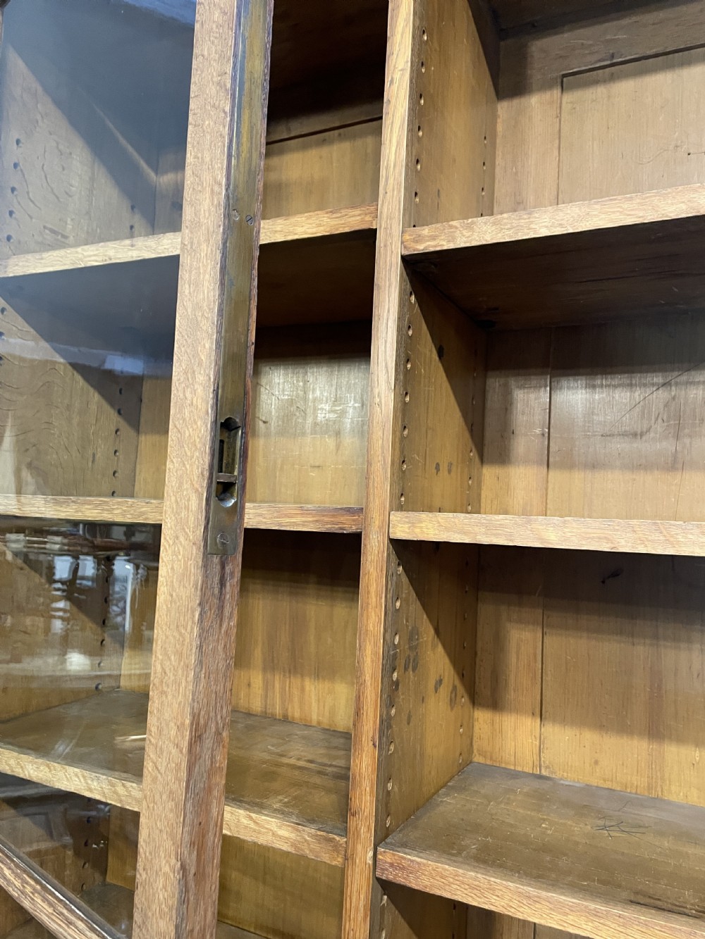 A tall Victorian light oak two-part bookcase with two upper glazed doors revealing adjustable shelves and a two-door cupboard base. View XVII