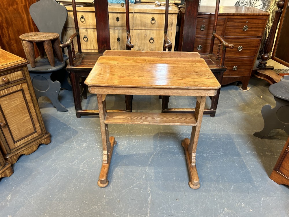 An early twentieth-century pine lectern table featuring a slanted reading surface with a retaining lip, supported by a trestle base with a lower shelf. View VI