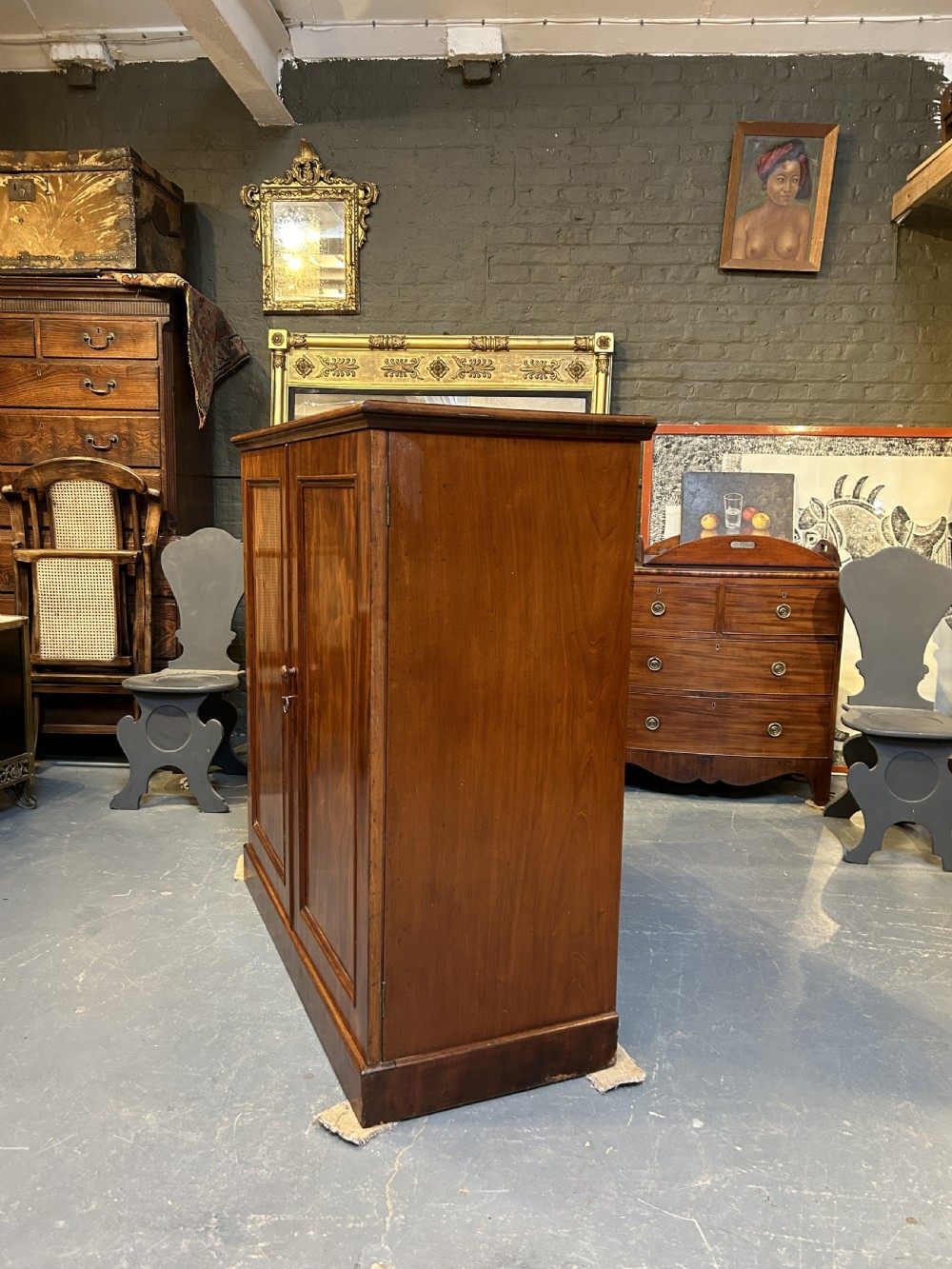 A 19th-century Victorian mahogany linen press cupboard featuring flame mahogany door panels resting on a solid plinth base. View III