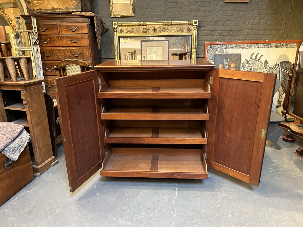 A 19th-century Victorian mahogany linen press cupboard featuring flame mahogany door panels resting on a solid plinth base. View IV