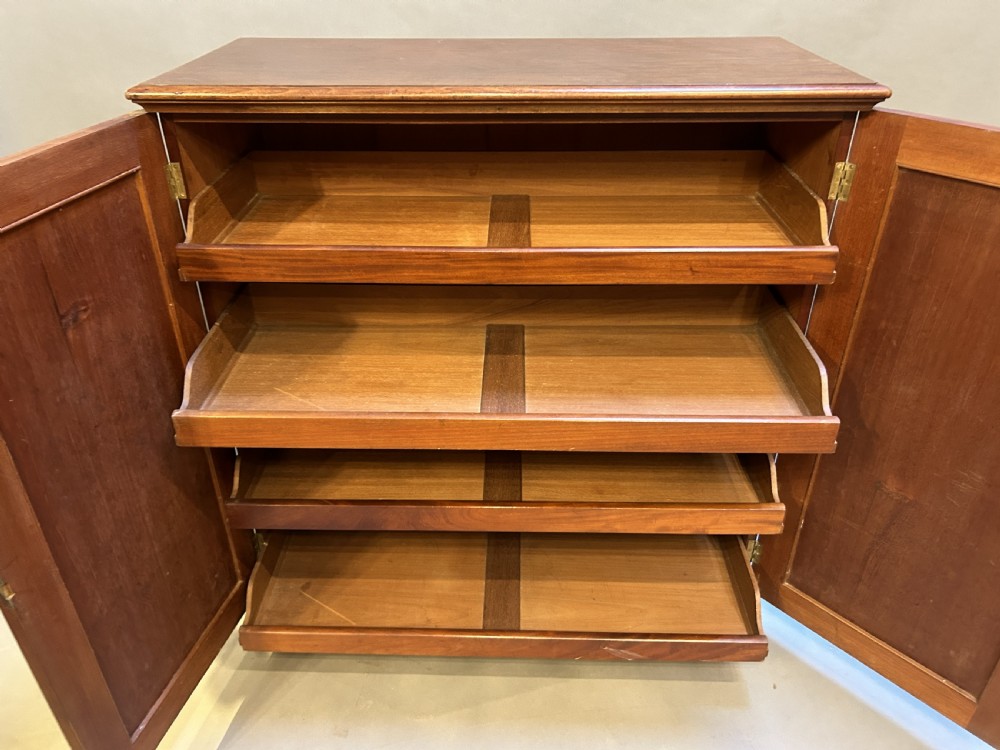 A 19th-century Victorian mahogany linen press cupboard featuring flame mahogany door panels resting on a solid plinth base. View XI