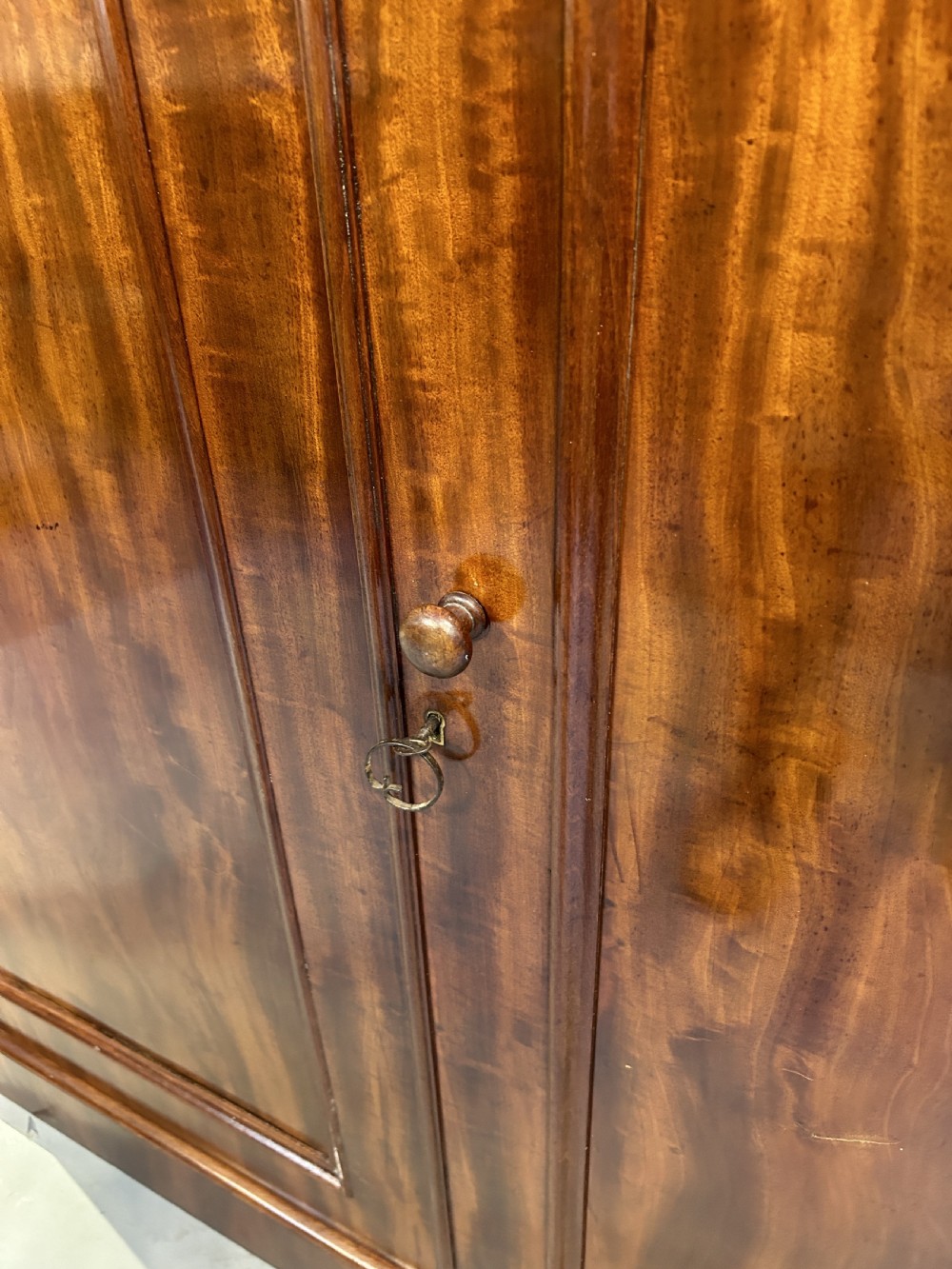 A 19th-century Victorian mahogany linen press cupboard featuring flame mahogany door panels resting on a solid plinth base. View XII