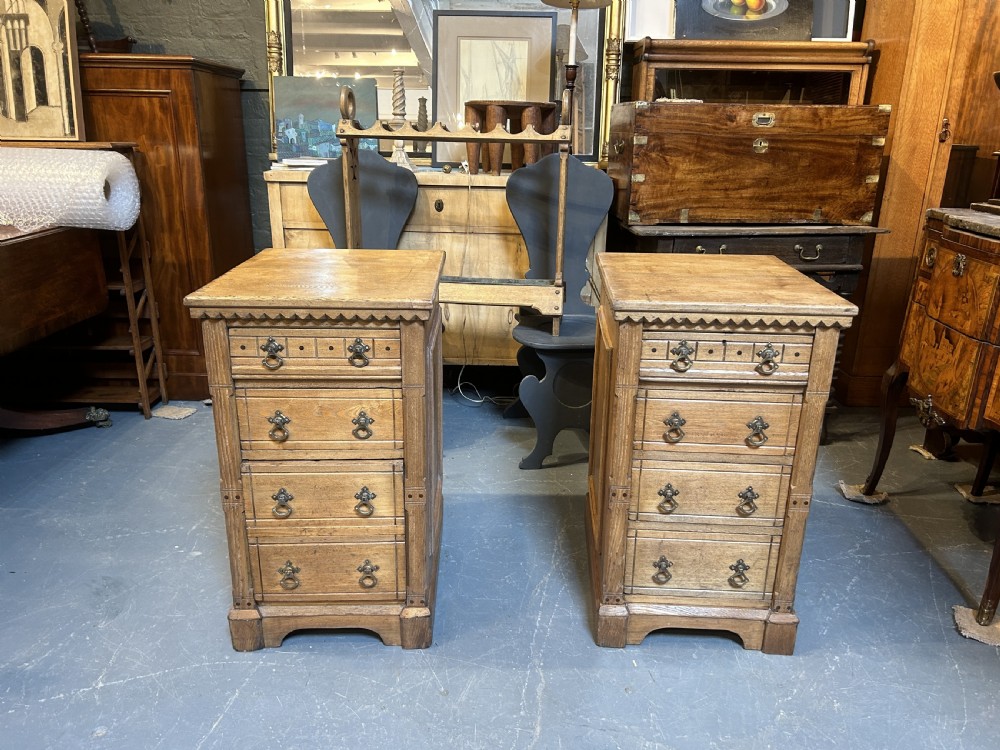 A pair of light oak four-drawer bedside chests featuring carved top edge details and brass drop handles. View III