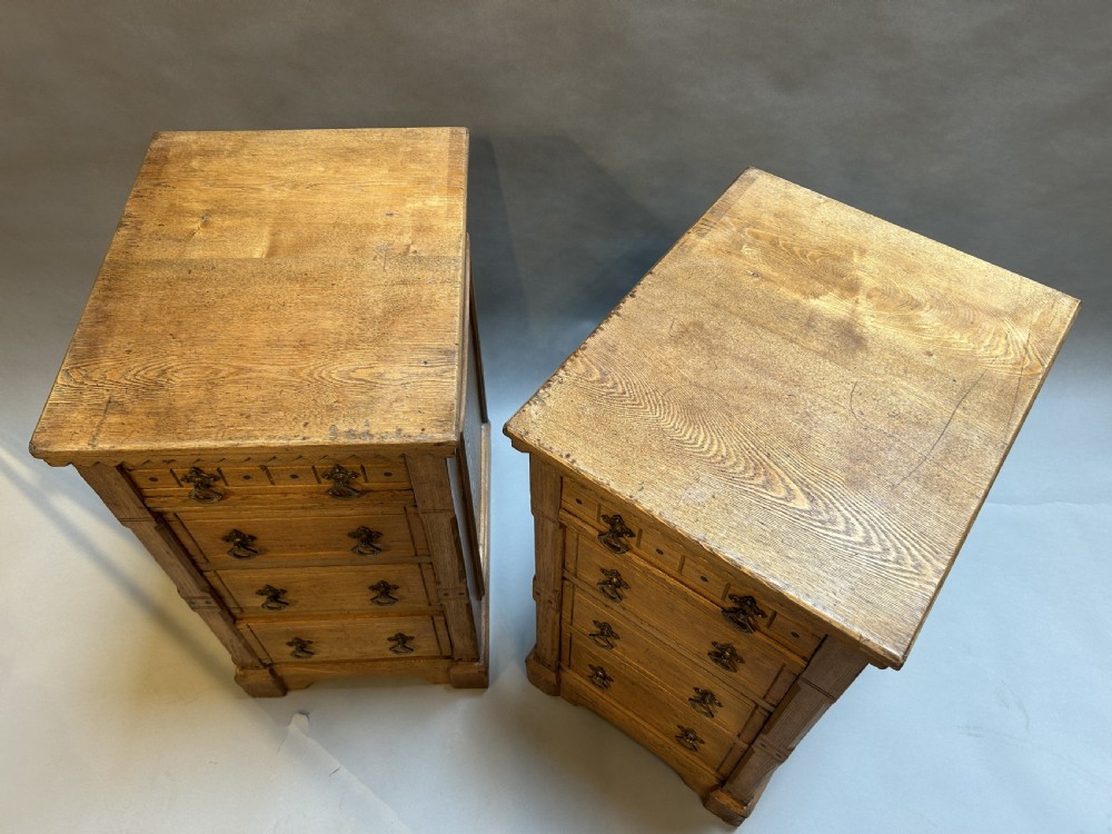 A pair of light oak four-drawer bedside chests featuring carved top edge details and brass drop handles. View IV