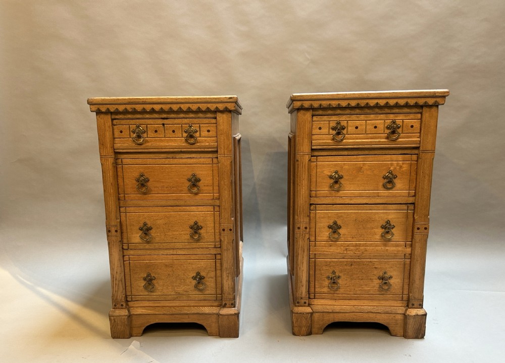 A pair of light oak four-drawer bedside chests featuring carved top edge details and brass drop handles. View VII