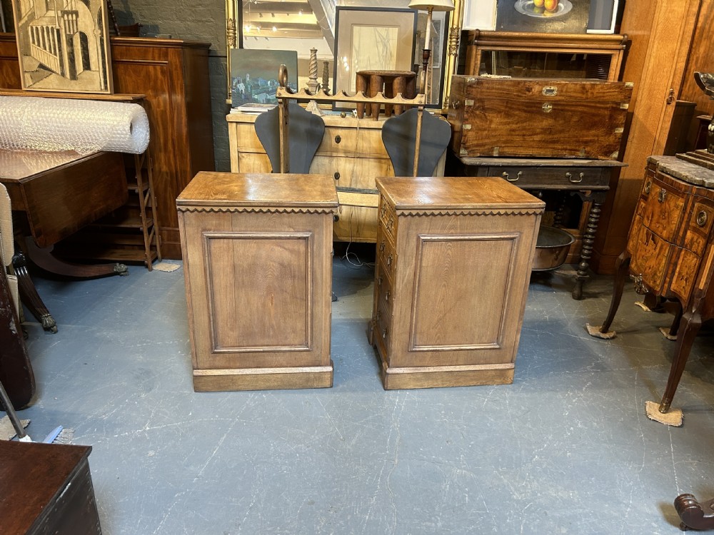 A pair of light oak four-drawer bedside chests featuring carved top edge details and brass drop handles. View VIII