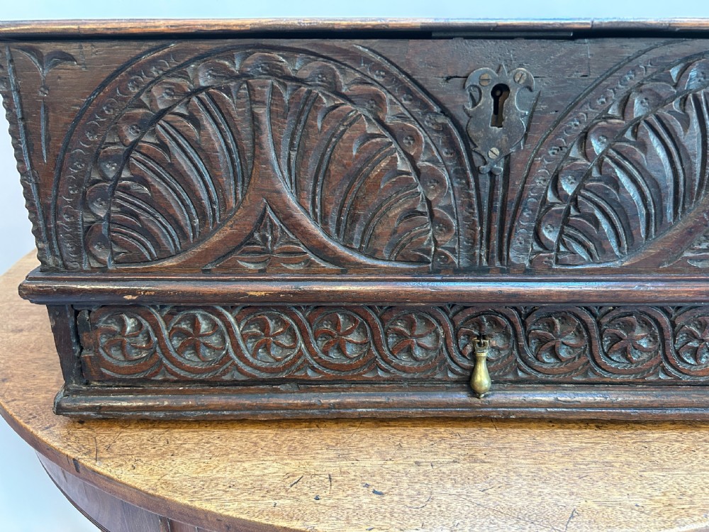 An eighteenth-century dark oak bible box featuring relief carved lunettes, a brass teardrop drawer pull, and a hinged lid. View III