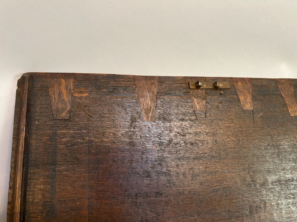 An eighteenth-century dark oak bible box featuring relief carved lunettes, a brass teardrop drawer pull, and a hinged lid. View IV