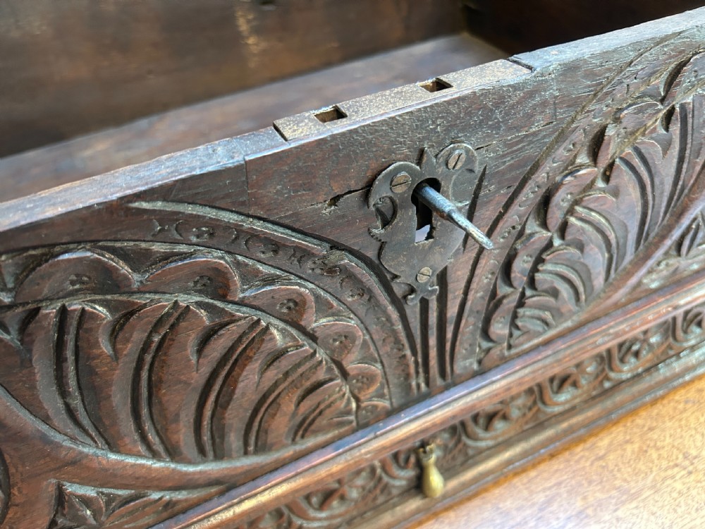 An eighteenth-century dark oak bible box featuring relief carved lunettes, a brass teardrop drawer pull, and a hinged lid. View V