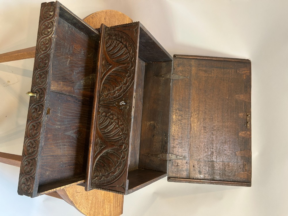 An eighteenth-century dark oak bible box featuring relief carved lunettes, a brass teardrop drawer pull, and a hinged lid. View VI