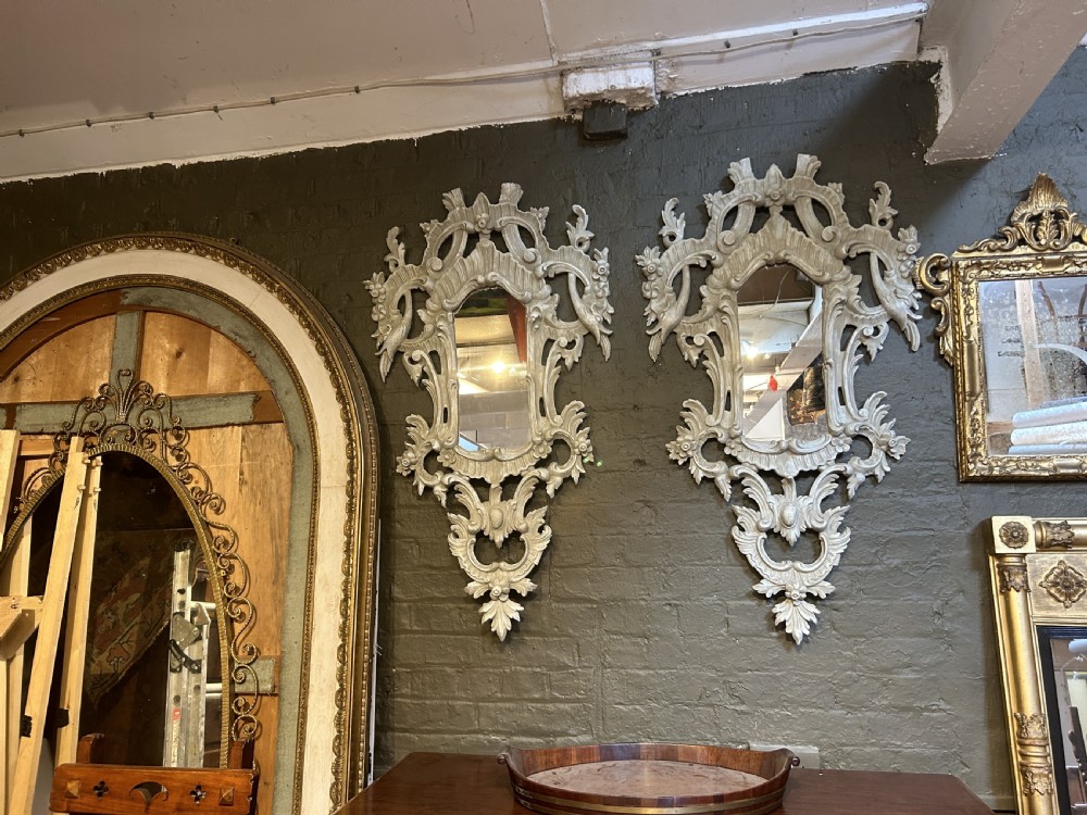 A 19th-century Continental wall mirror with an ornate carved off-white frame featuring intricate scrollwork, acanthus leaves, and shell motifs. View VI
