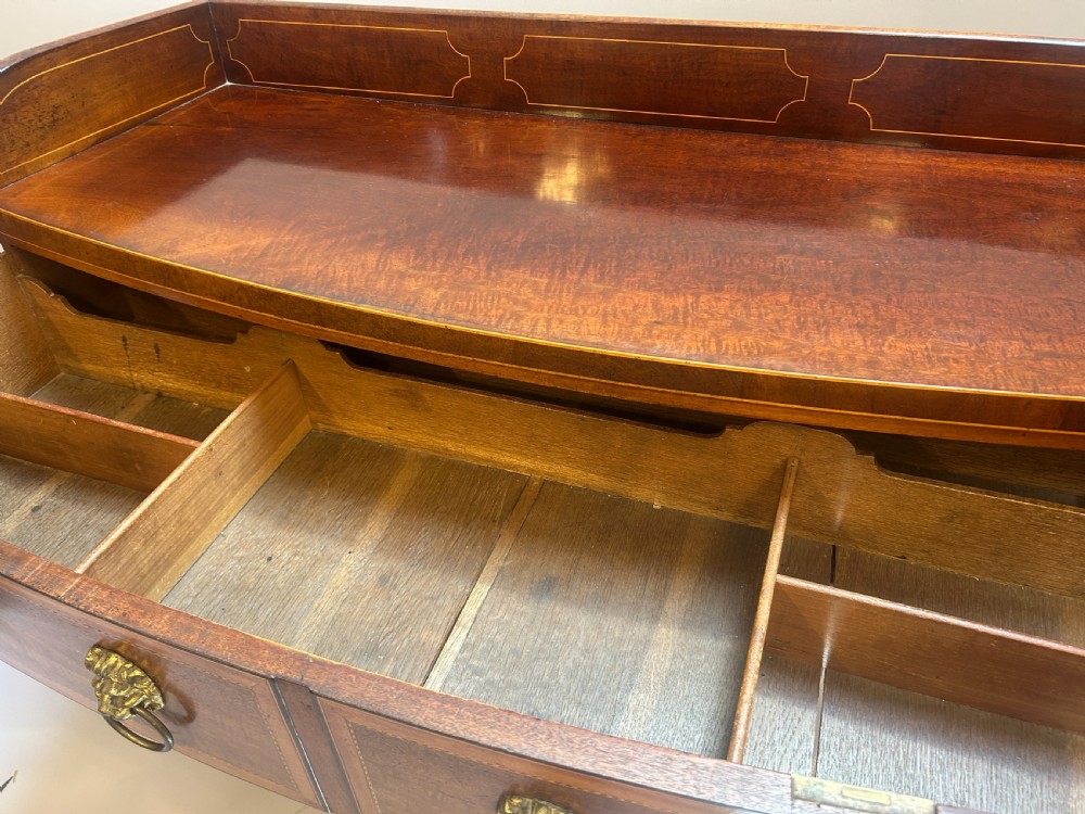 A George IV mahogany sideboard featuring a gallery back, geometric wood inlay, brass lion-mask handles, and pedestal cupboards flanking a central drawer. View III
