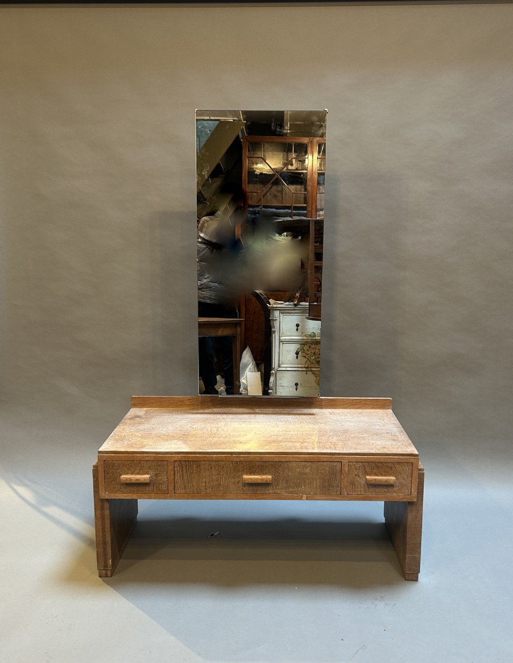 An Art Deco light oak dressing chest featuring three frieze drawers with wooden block handles and a tall rectangular mirror. View VI