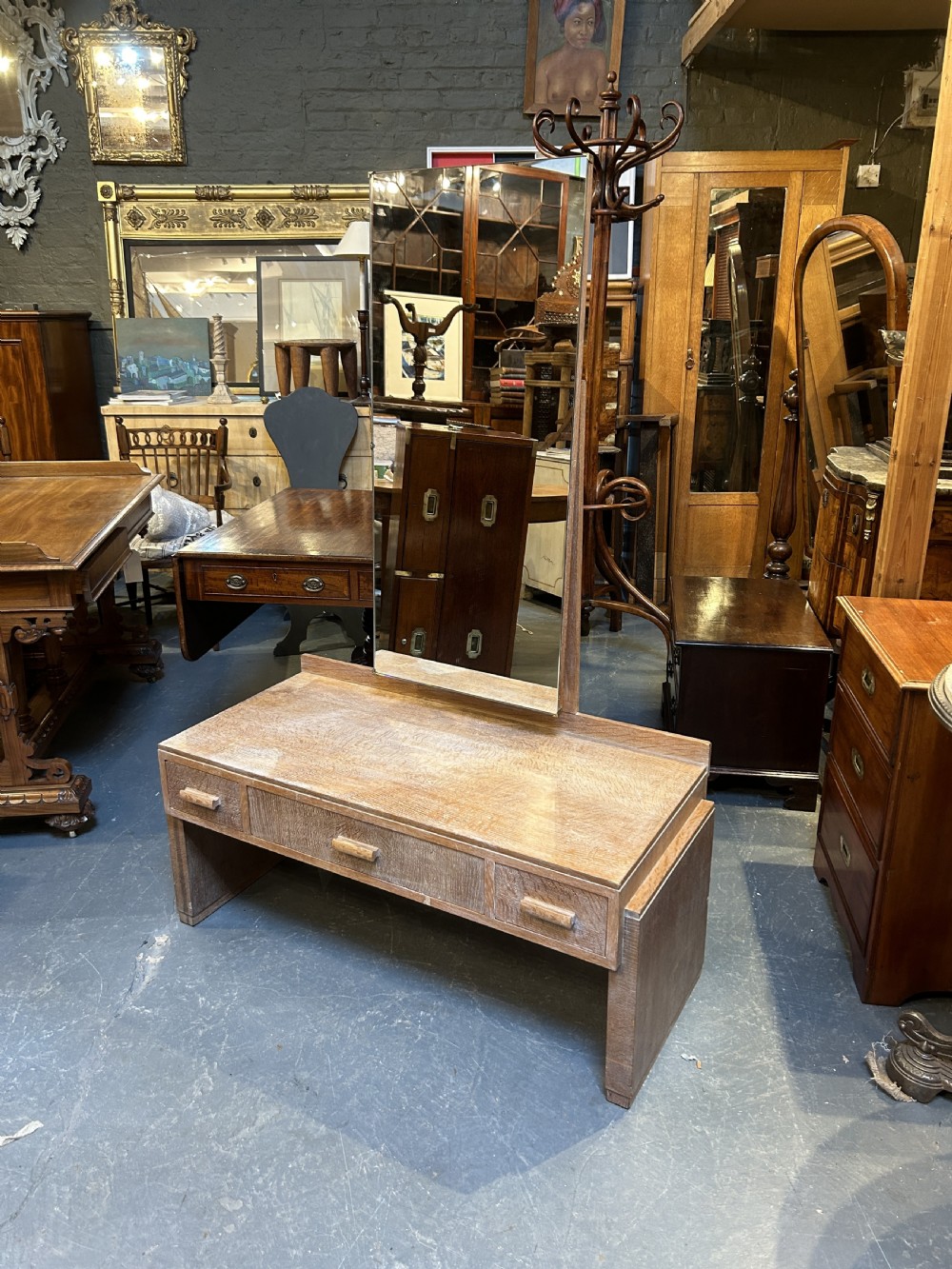 An Art Deco light oak dressing chest featuring three frieze drawers with wooden block handles and a tall rectangular mirror. View VIII