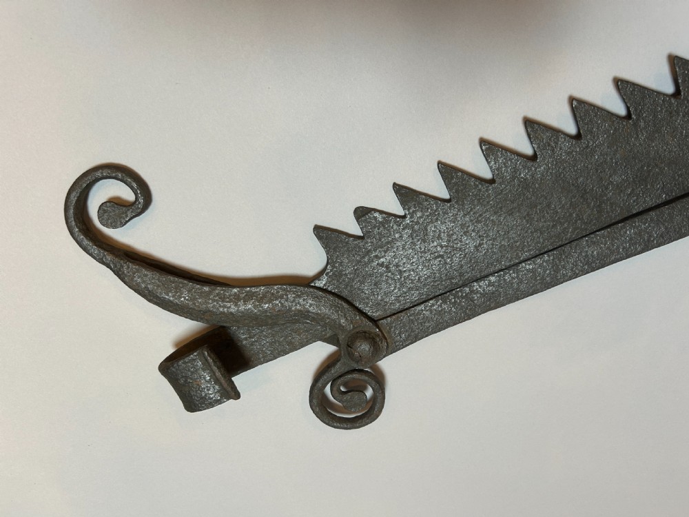An 18th-century hand-forged wrought iron adjustable chimney crane featuring a sawtooth trammel mechanism, scrolled ends, and a decorative rosette. View IV