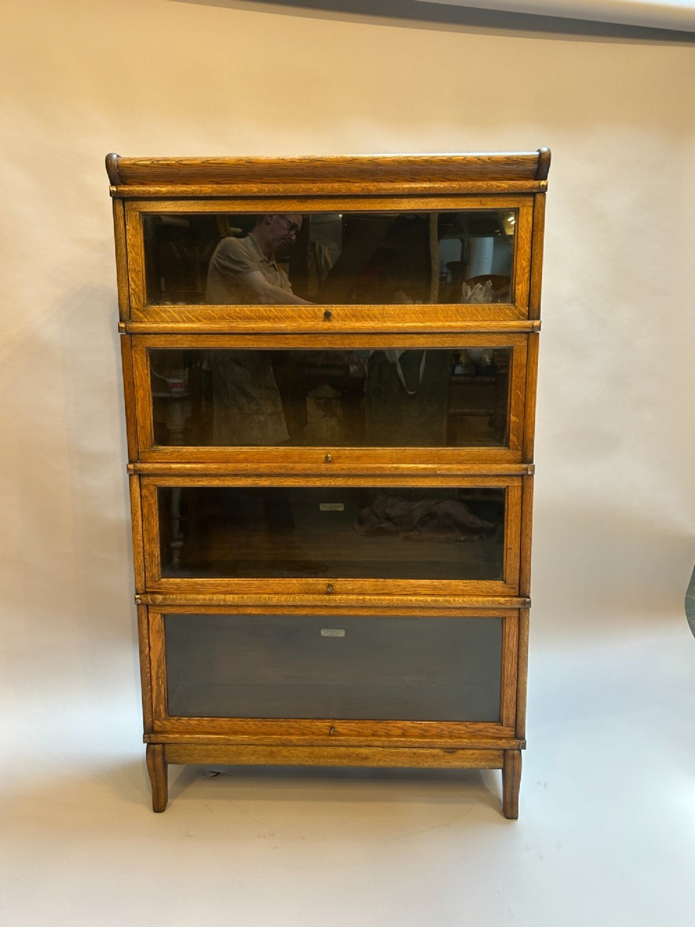 A four-tier oak Globe Wernicke stacking barrister bookcase with glazed up-and-over doors. View II