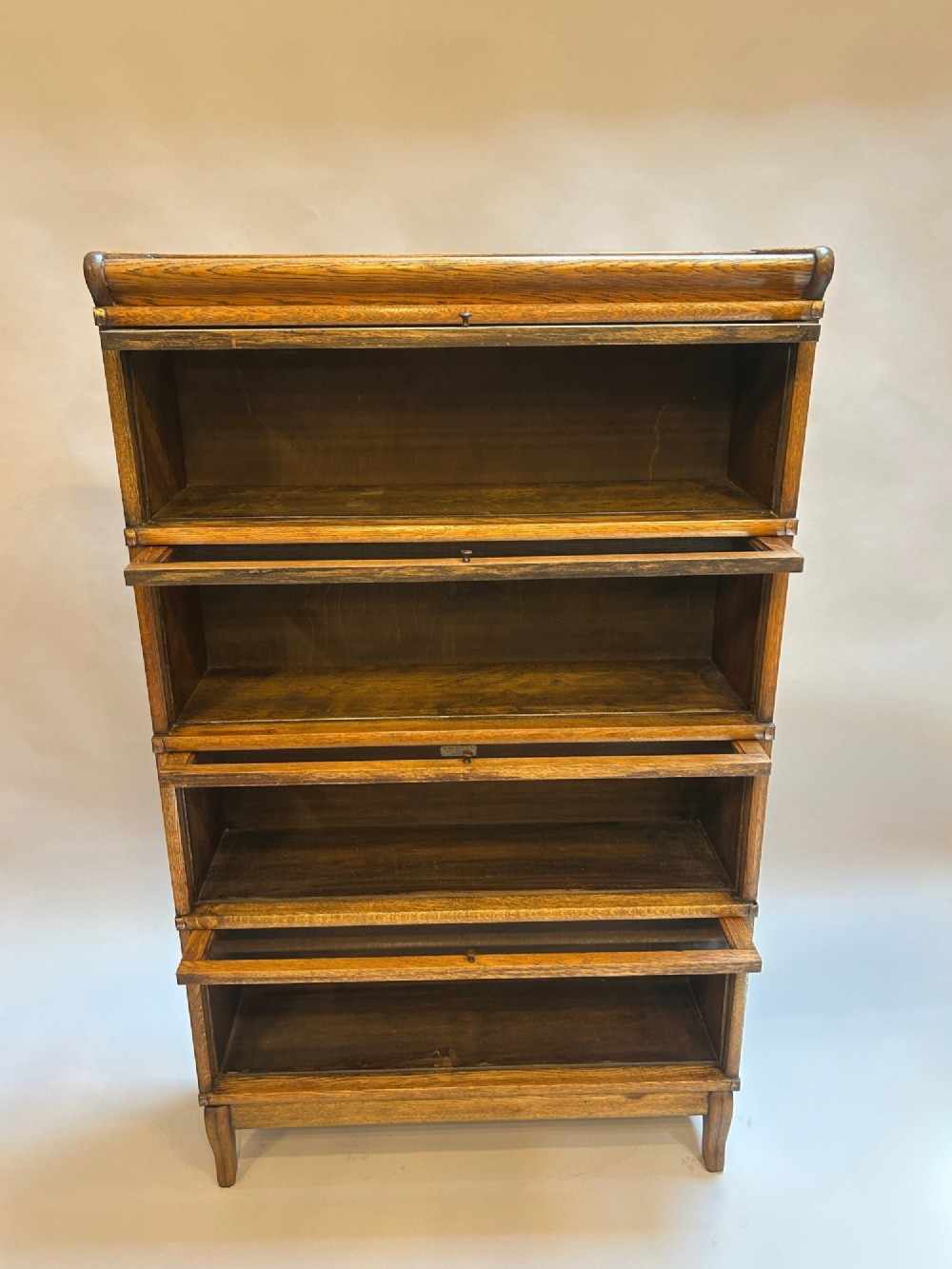 A four-tier oak Globe Wernicke stacking barrister bookcase with glazed up-and-over doors. View V