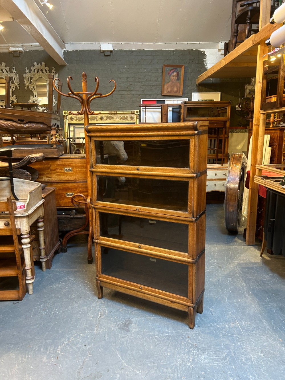 A four-tier oak Globe Wernicke stacking barrister bookcase with glazed up-and-over doors. View VII