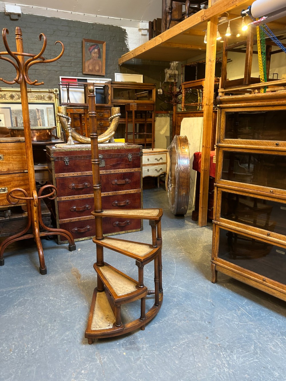 A set of spiral mahogany library steps featuring leather-lined treads and a tall central handrail post styled with faux-bamboo turnings and a brass finial. View VII