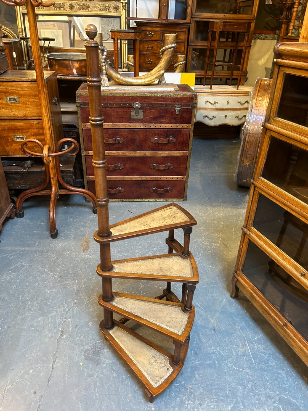 A set of spiral mahogany library steps featuring leather-lined treads and a tall central handrail post styled with faux-bamboo turnings and a brass finial. View VIII