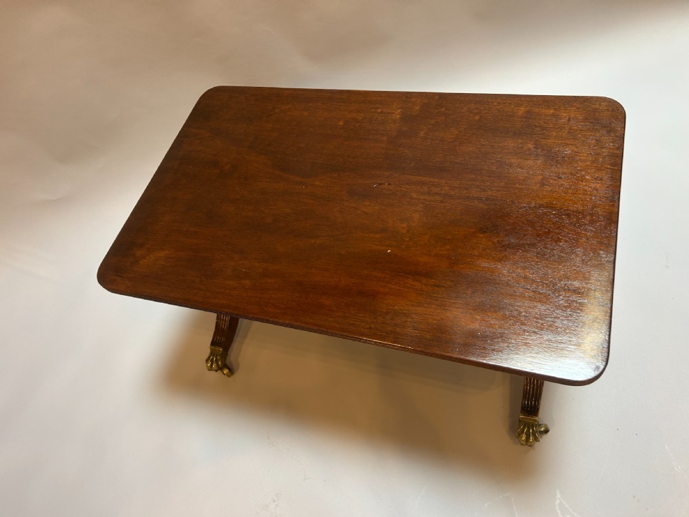 A rectangular George IV mahogany coffee table featuring reeded sweeping legs with brass lion paw castors. View II