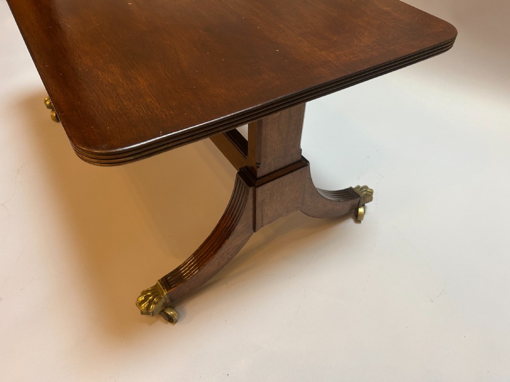 A rectangular George IV mahogany coffee table featuring reeded sweeping legs with brass lion paw castors. View III