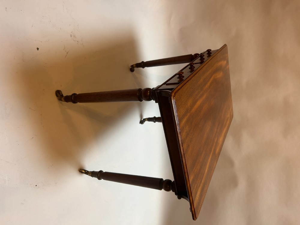 A Victorian mahogany writing table featuring two frieze drawers with turned wooden knob handles and turned legs supported by brass castors. View IX