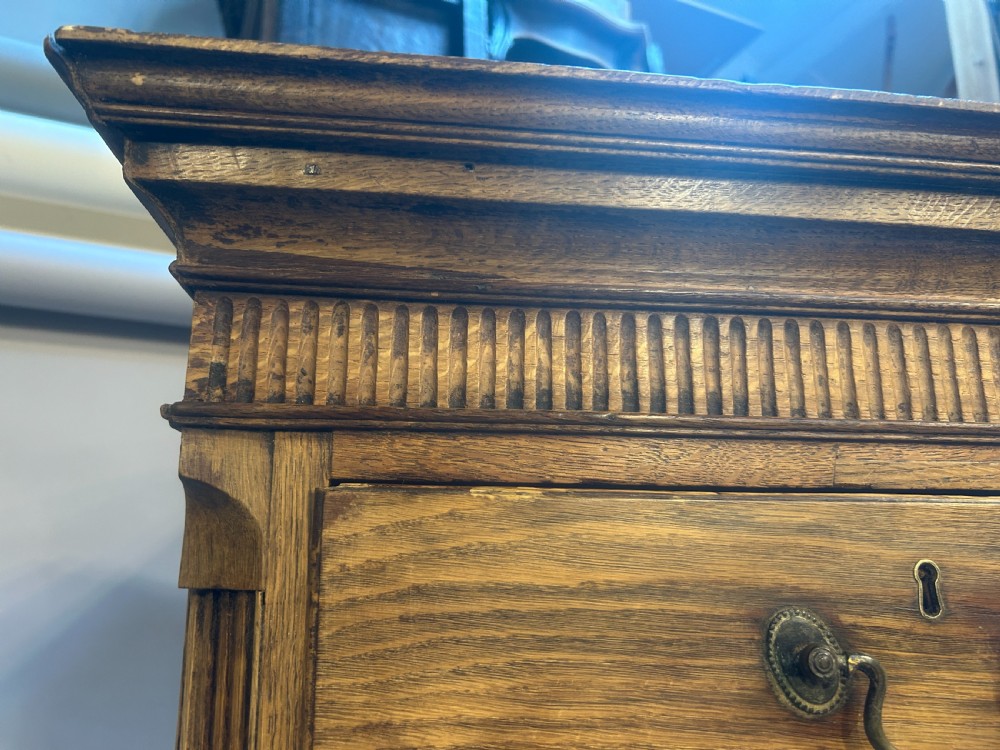 A George III oak tallboy chest-on-chest displaying two short over six long drawers fitted with brass swan-neck drop handles and supported on bracket feet. View VII