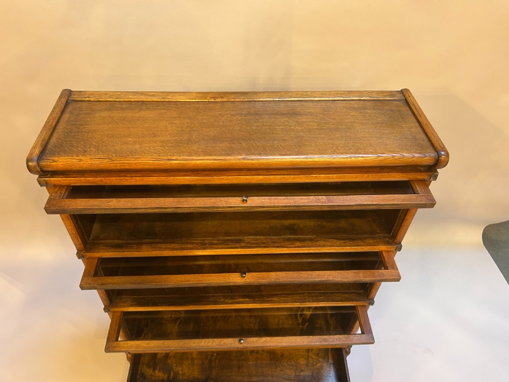 A three-tier antique oak Globe Wernicke stacking bookcase featuring glazed lift-up doors and a base drawer. View VIII