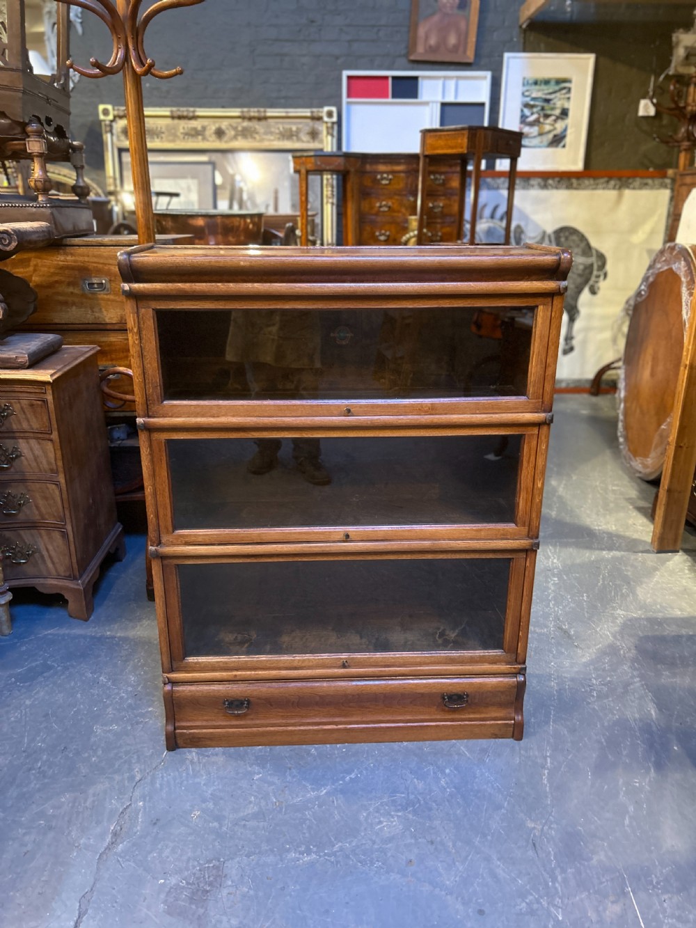 A three-tier antique oak Globe Wernicke stacking bookcase featuring glazed lift-up doors and a base drawer. View XI