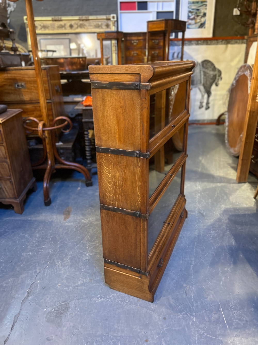 A three-tier antique oak Globe Wernicke stacking bookcase featuring glazed lift-up doors and a base drawer. View XII