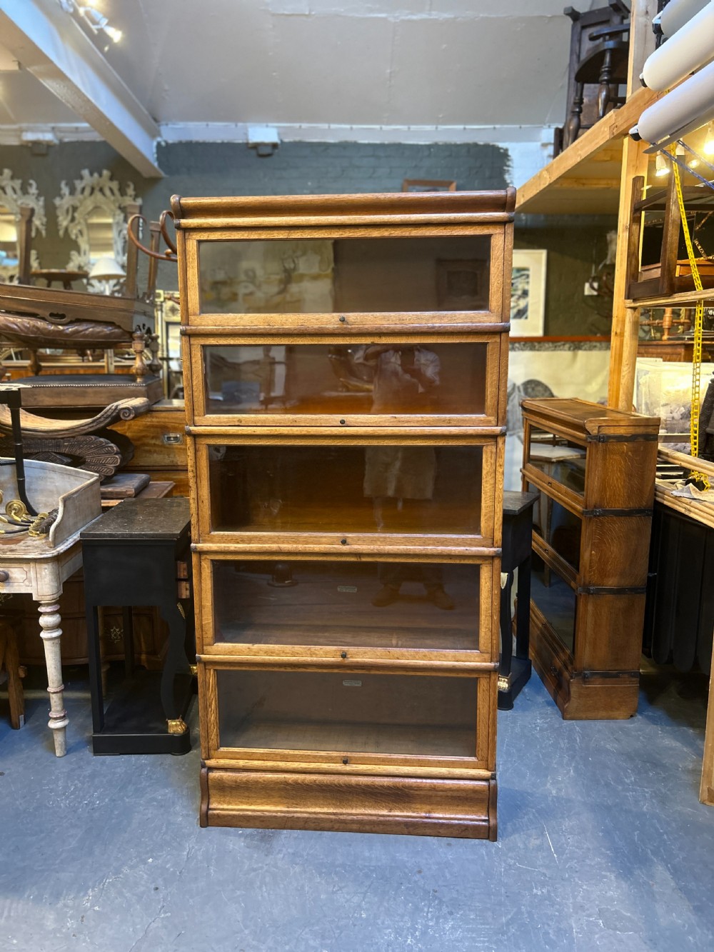 A five-tier antique golden oak Globe Wernicke stacking bookcase with glazed door fronts and side metal bands. View XII