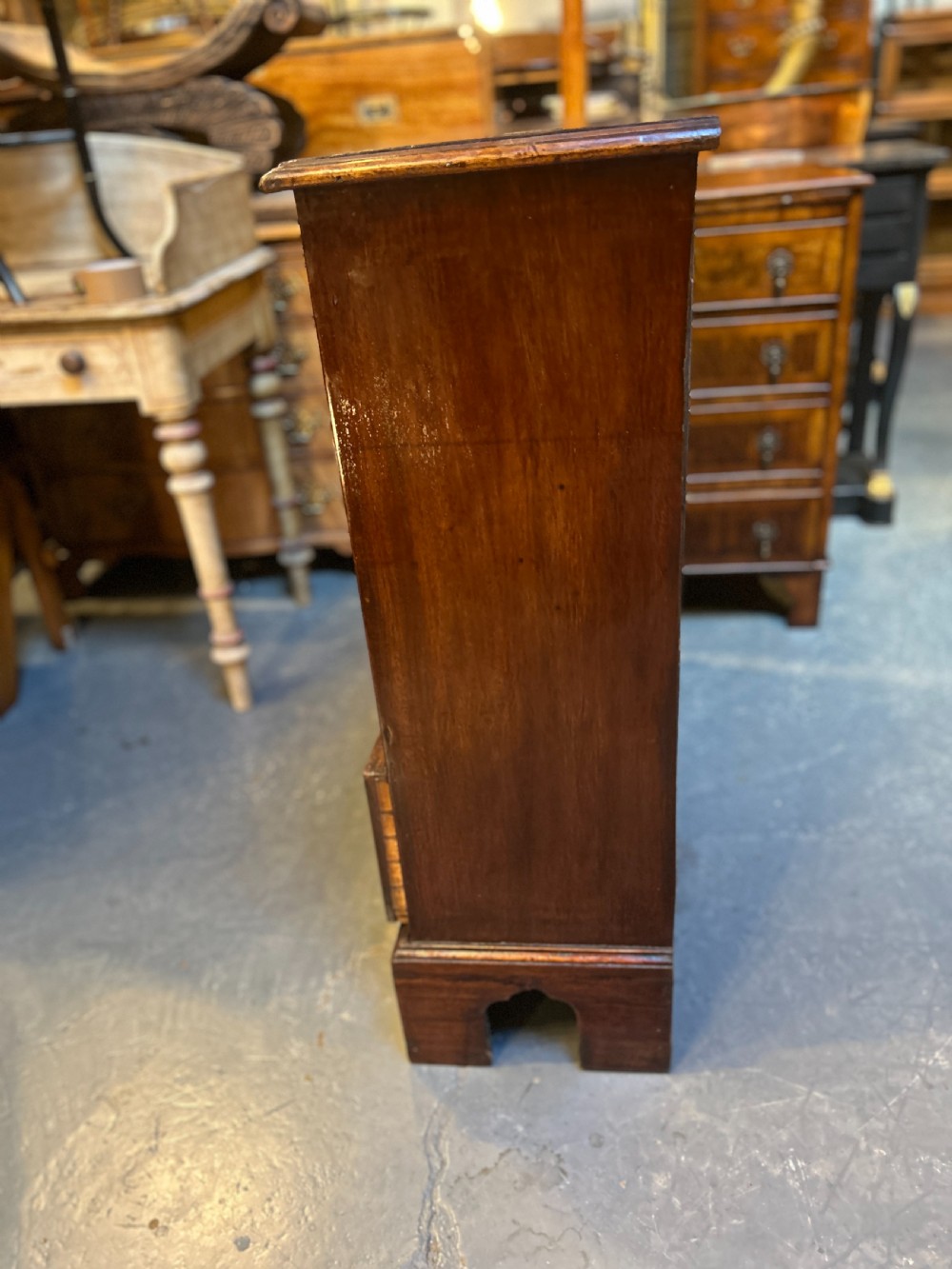 A George III dark mahogany hall chest of drawers with four graduated drawers, oval brass handles, and bracket feet. View IX