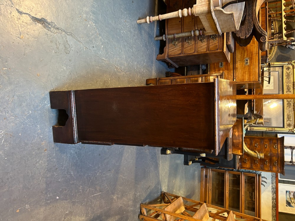 A George III dark mahogany hall chest of drawers with four graduated drawers, oval brass handles, and bracket feet. View XI