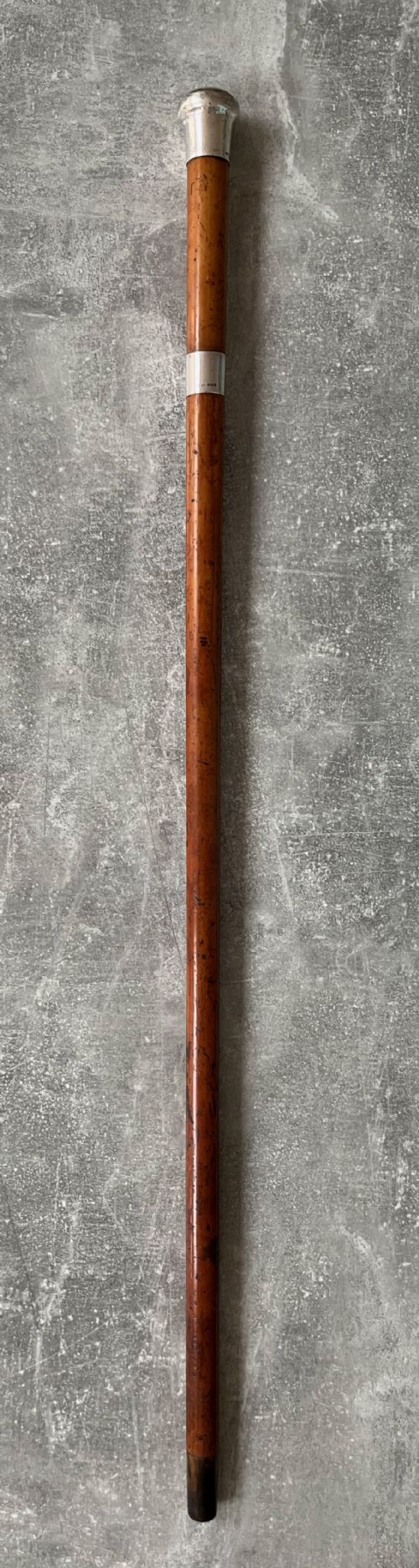 fig 1. An antique malacca cane sword stick featuring a hallmarked silver pommel collar and an etched steel blade alongside its wooden sheath.