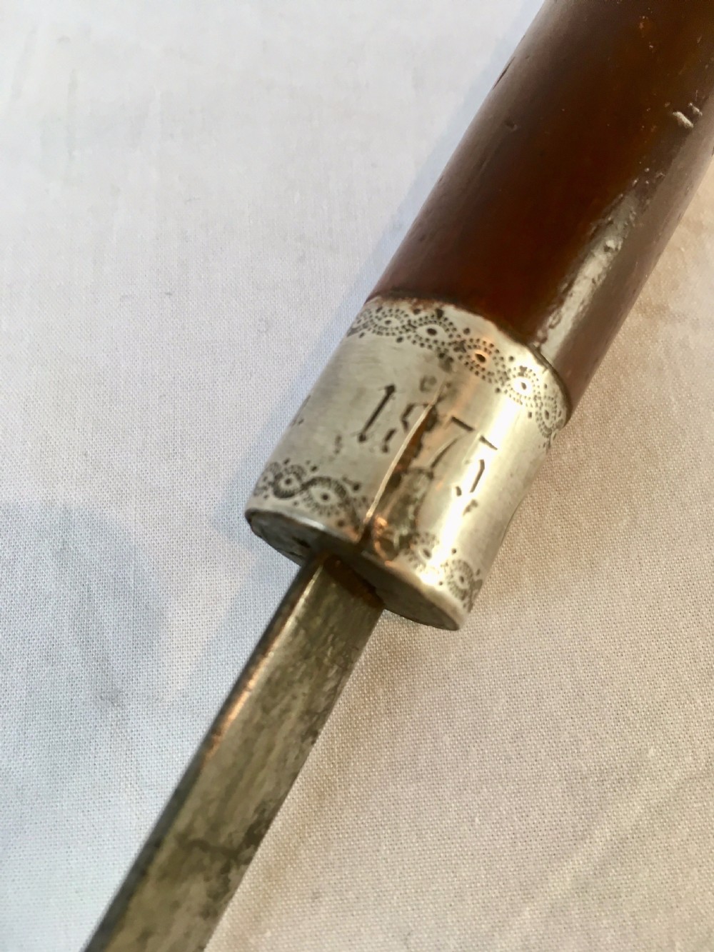 A Victorian hardwood sword stick separated to display a long steel blade beside its dark wooden sheath with a silver collar. View III