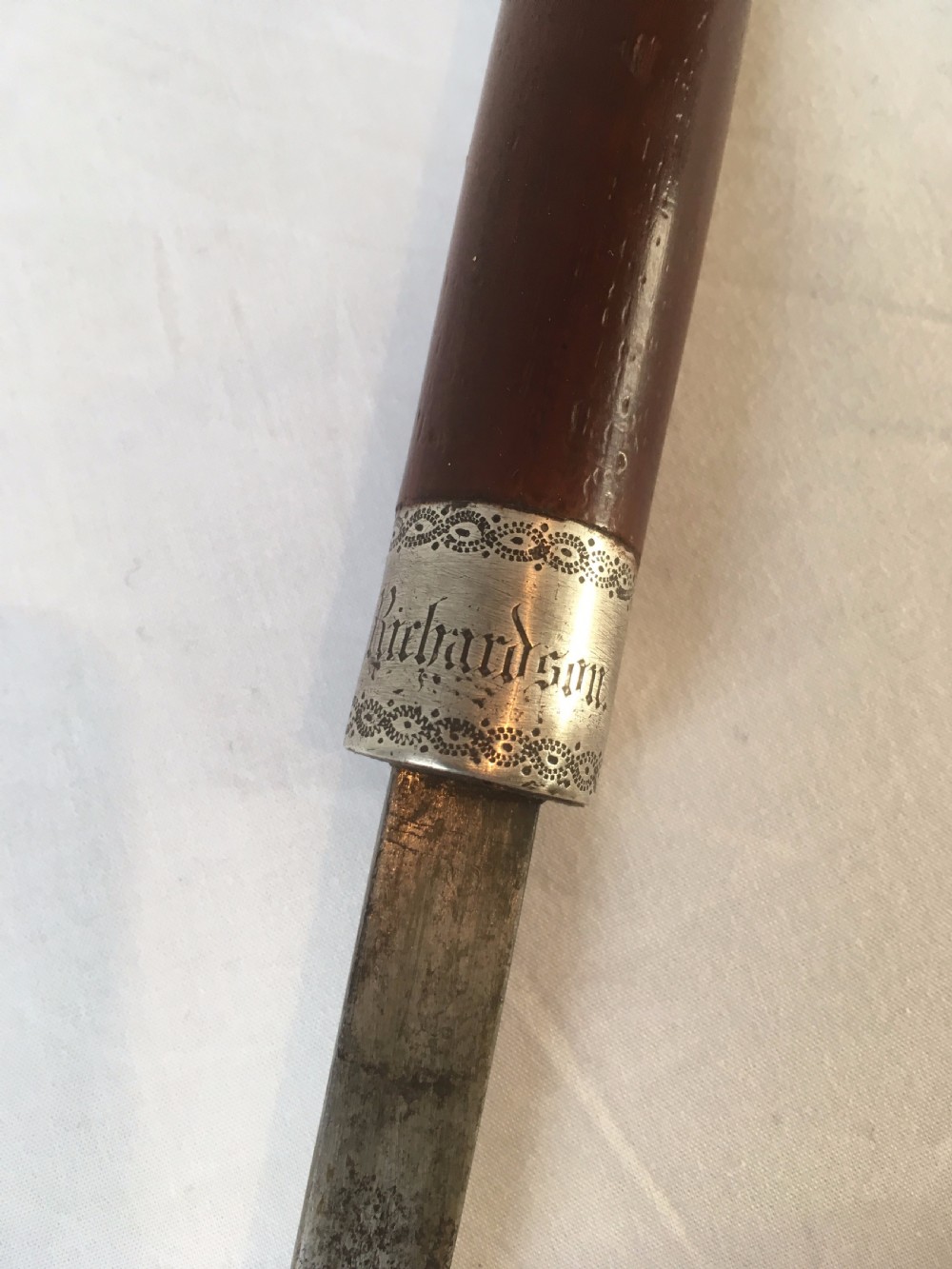 A Victorian hardwood sword stick separated to display a long steel blade beside its dark wooden sheath with a silver collar. View IV