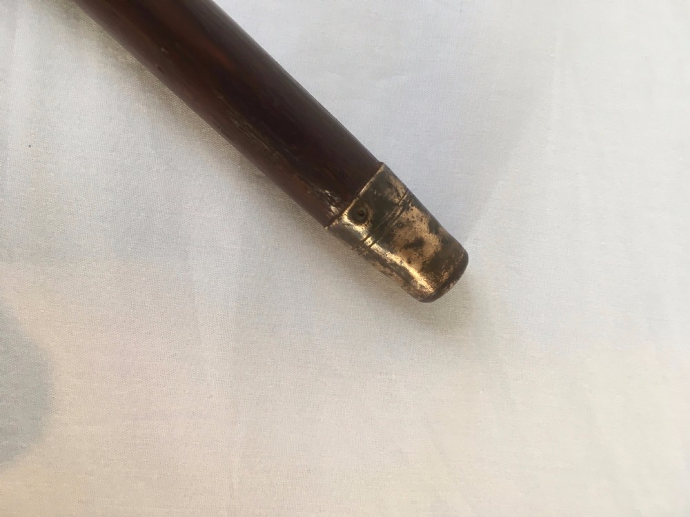 A Victorian hardwood sword stick separated to display a long steel blade beside its dark wooden sheath with a silver collar. View IX