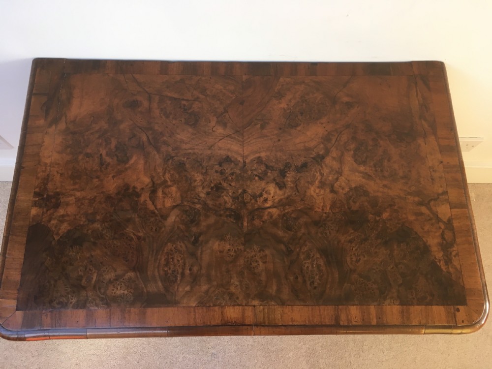 An eighteenth-century George II burr walnut lowboy featuring three drawers, brass handles, a shaped apron, and four slender cabriole legs. View VI