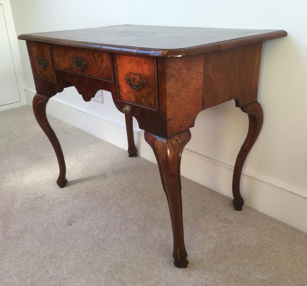 An eighteenth-century George II burr walnut lowboy featuring three drawers, brass handles, a shaped apron, and four slender cabriole legs. View VIII