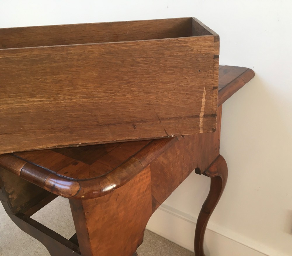 An eighteenth-century George II burr walnut lowboy featuring three drawers, brass handles, a shaped apron, and four slender cabriole legs. View XI