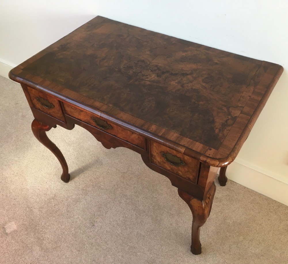An eighteenth-century George II burr walnut lowboy featuring three drawers, brass handles, a shaped apron, and four slender cabriole legs. View XIII