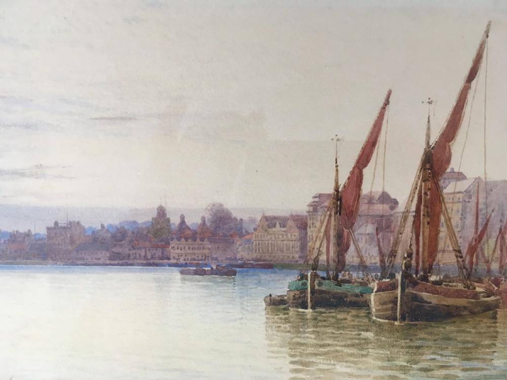 A pair of horizontally framed watercolour paintings depicting Thames sailing barges on calm water, enclosed in matching gilt frames with double mounts. View III