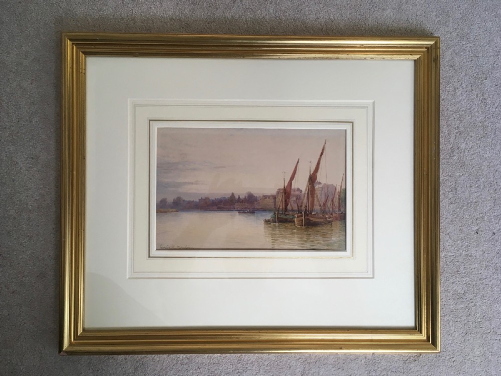 A pair of horizontally framed watercolour paintings depicting Thames sailing barges on calm water, enclosed in matching gilt frames with double mounts. View VIII