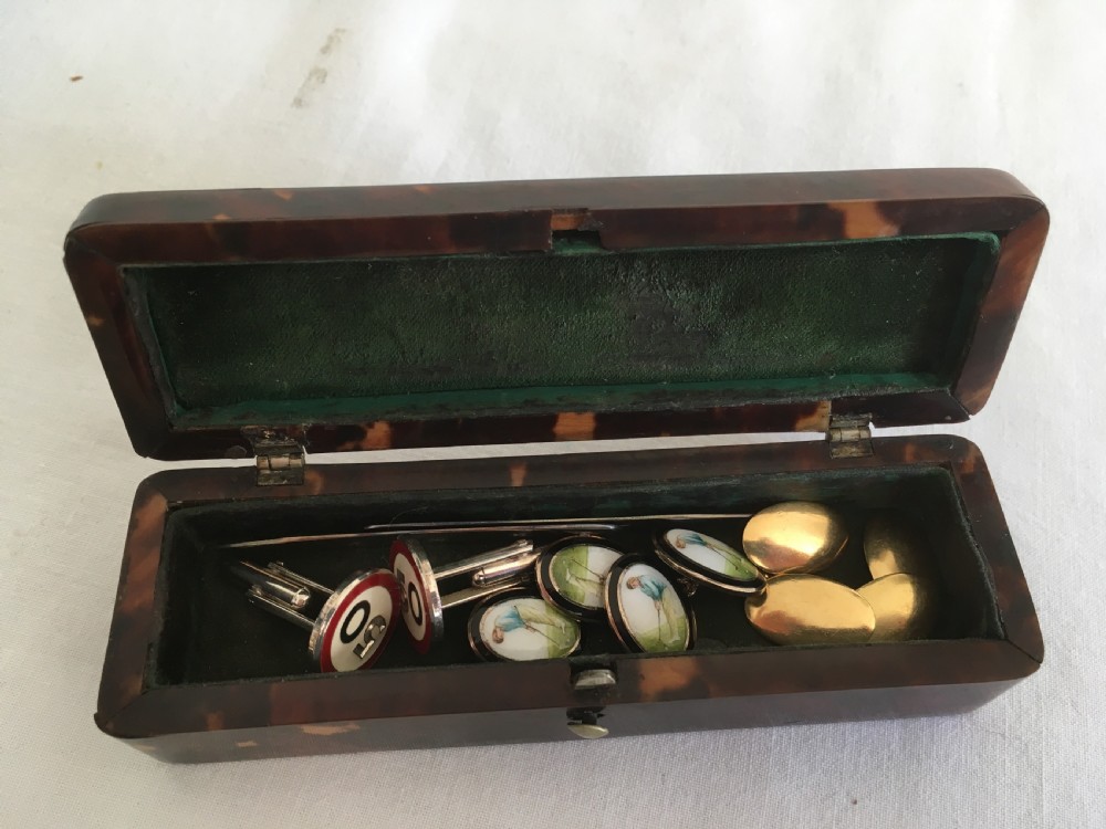 A rectangular mottled tortoiseshell box with rounded corners and an oval silver monogrammed plaque mounted on the lid. View II
