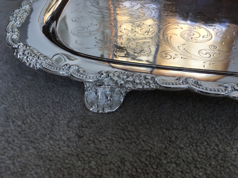 A 19th-century rectangular silver-plated serving tray featuring engraved foliate scrollwork, a decorative rim, and two cast side handles. View V