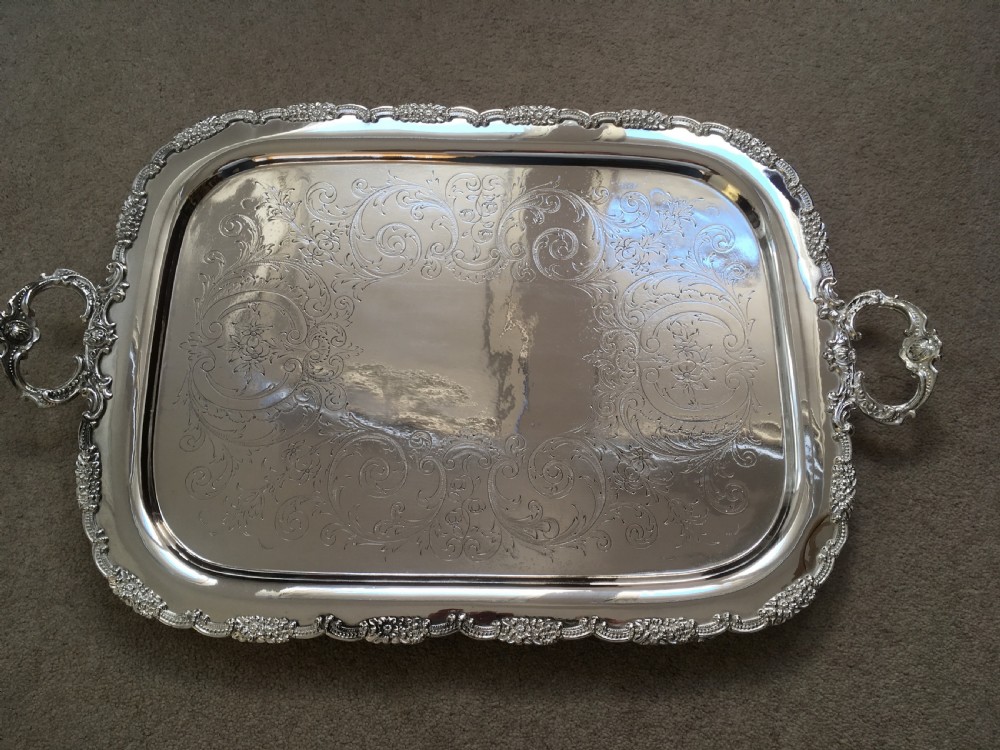 A 19th-century rectangular silver-plated serving tray featuring engraved foliate scrollwork, a decorative rim, and two cast side handles. View VIII