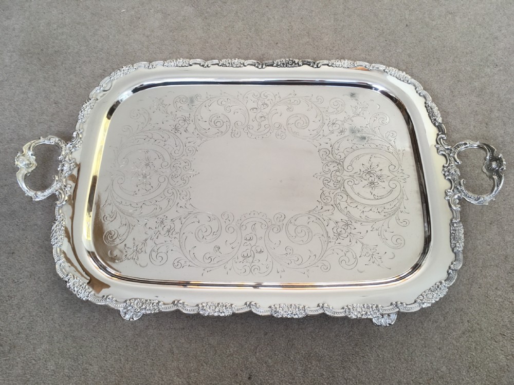 A 19th-century rectangular silver-plated serving tray featuring engraved foliate scrollwork, a decorative rim, and two cast side handles. View IX