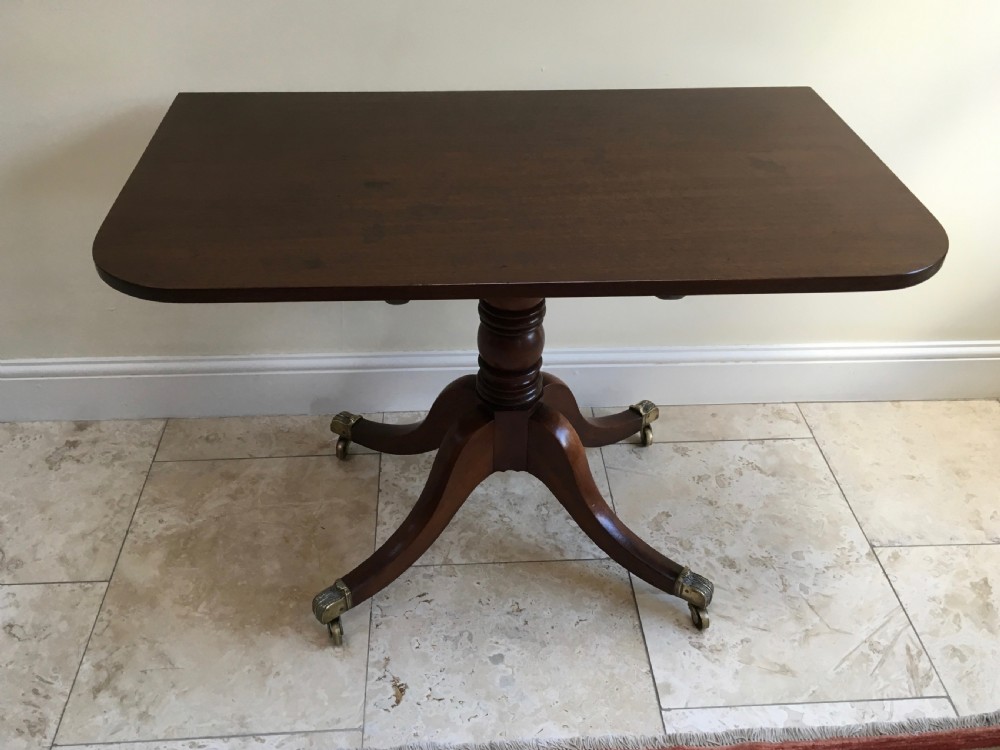 A 19th-century mahogany extendable dining table featuring a polished rectangular top with rounded corners, supported by two turned pillar pedestals on splayed legs with brass castors. View XIV